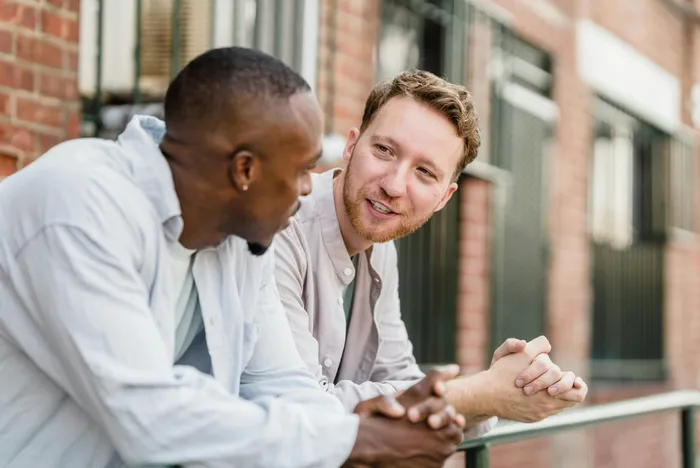 Two men having a friendly, supportive conversation outdoors in the neighborhood